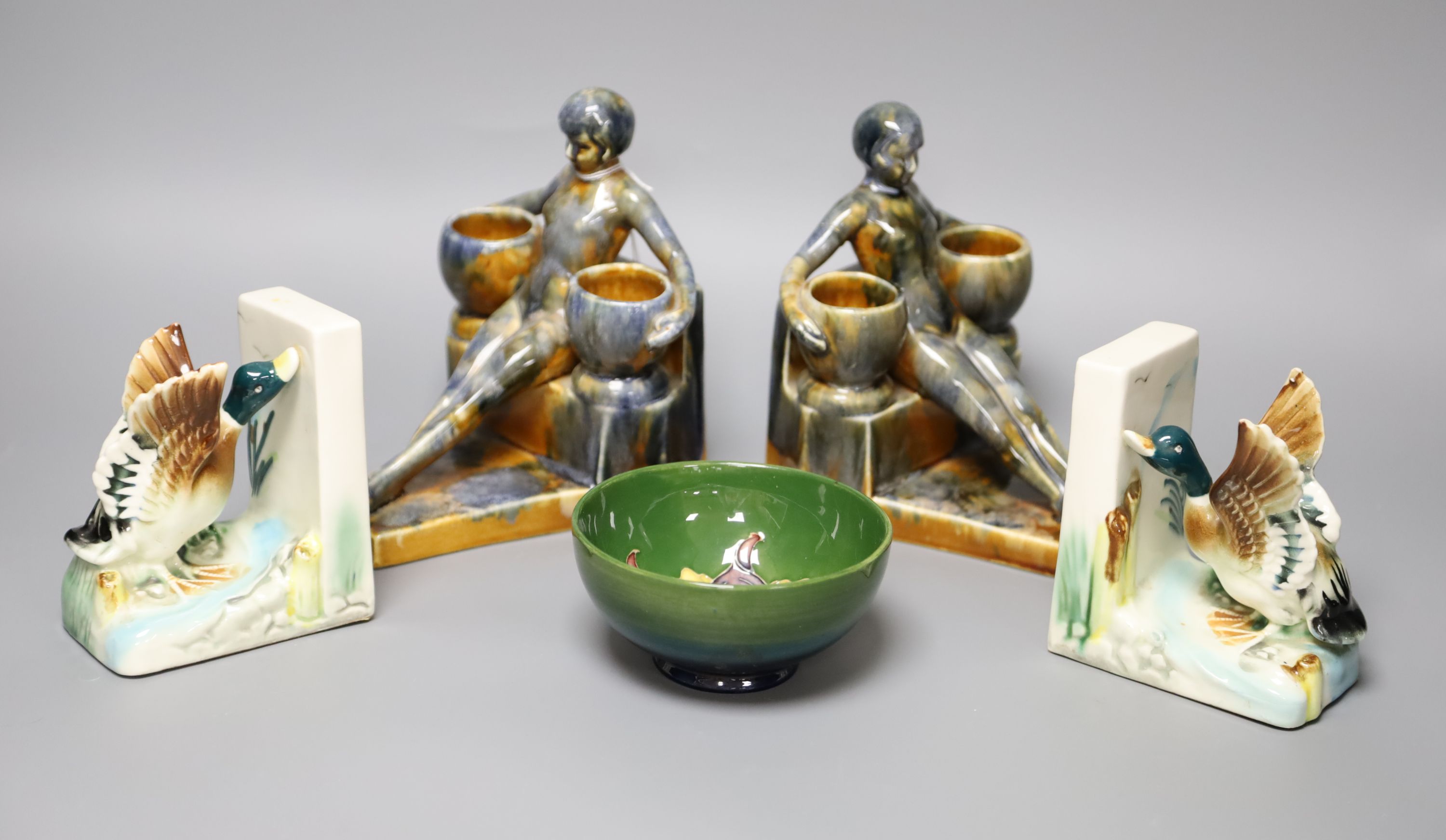 A Moorcroft green ground 'Columbine' pattern bowl, Dia 11cm and two pairs of ceramic bookends,